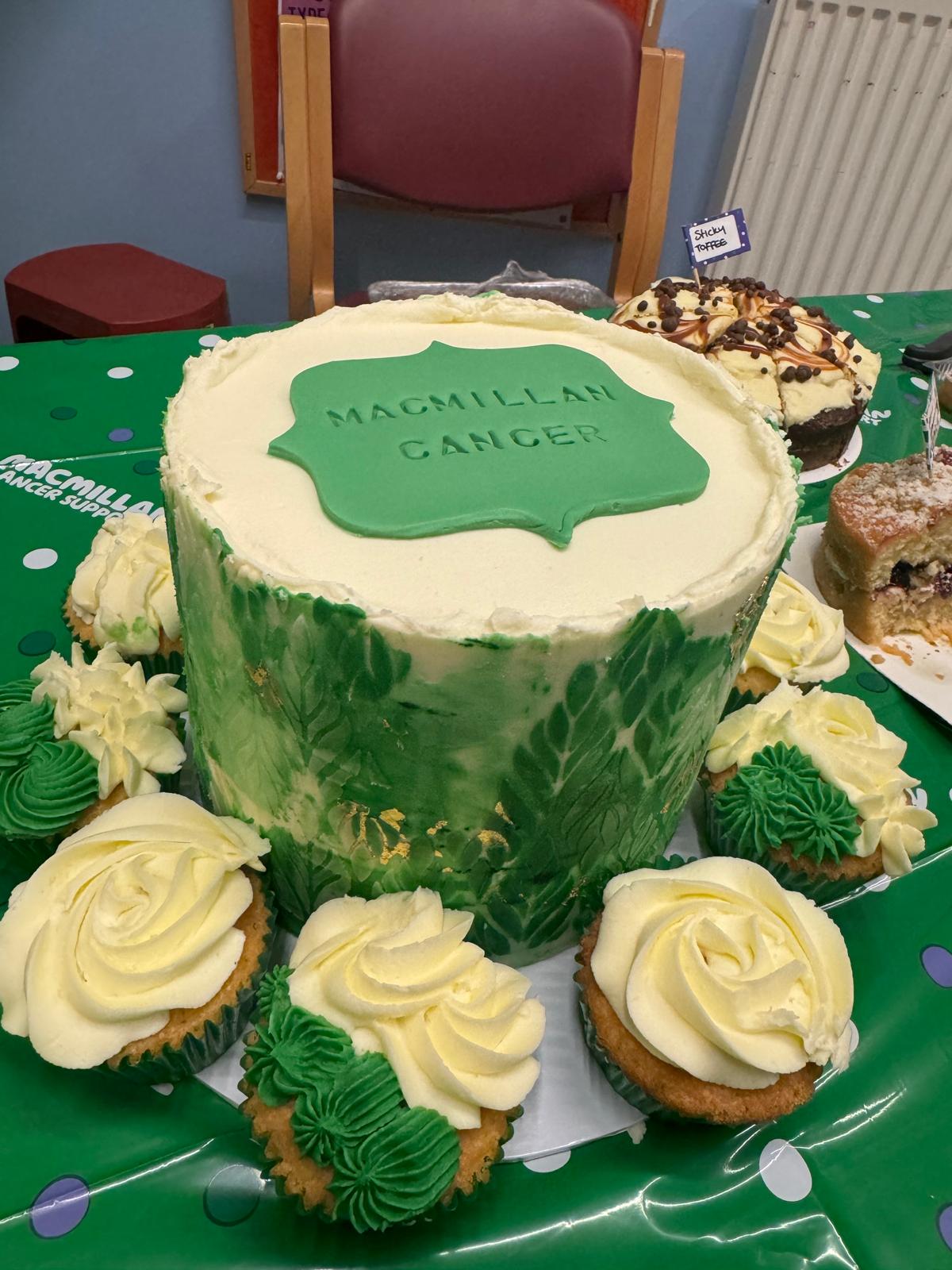 A large cake surrounded by cupcakes